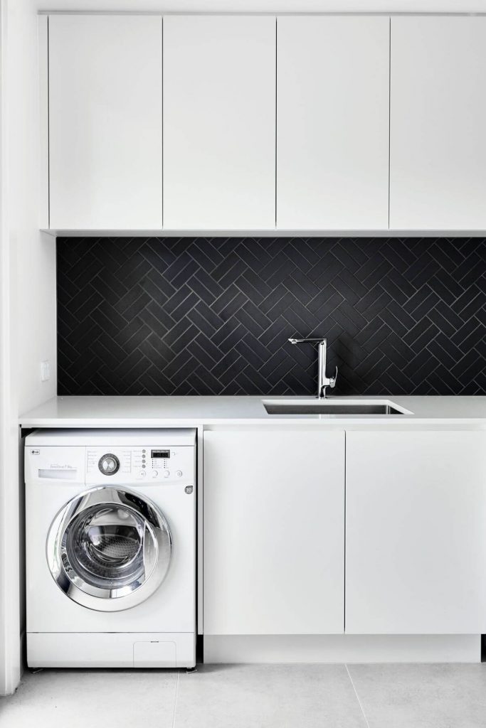 laundry with black splashback in a luxury modern home